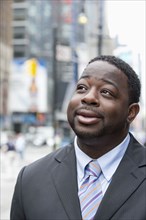 Black businessman smiling on urban street