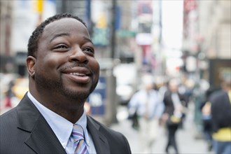 Black businessman smiling on urban street