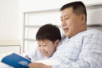 Chinese father reading book to son