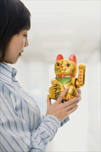Chinese woman looking at beckoning cat