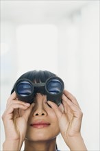 Chinese woman looking through binoculars