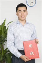 Chinese man holding paper with Chinese symbols