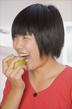Chinese woman biting apple