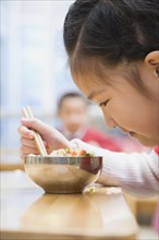 Chinese girl looking at food in bowl
