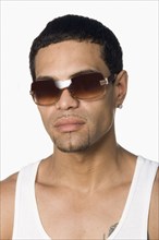 Hispanic man wearing sunglasses and looking serious
