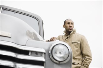 African American man standing next to old-fashioned truck