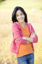 Hispanic girl in field with arms crossed