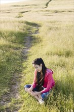 Hispanic girl sitting in field