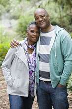 Smiling African American couple hugging in park