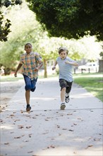 Boys running on sidewalk