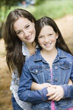 Caucasian mother hugging daughter