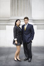 Business people standing near stone column