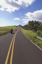 Motorcyclists riding on country road