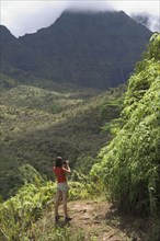 High angle view of woman looking out over lush jungle valley