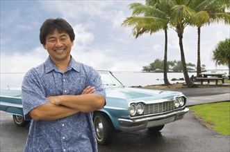 Asian man in front of car