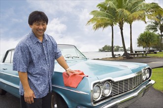 Asian man waxing car