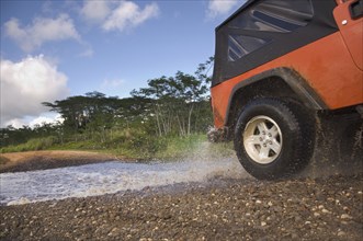 4x4 driving through water on remote road
