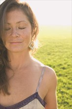 Portrait of woman in sunlit meadow