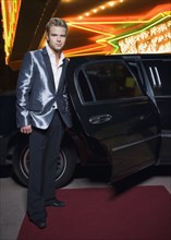German man standing by limousine outside nightclub