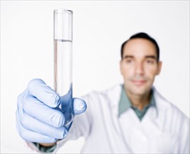 Hispanic scientist holding test tube full of water