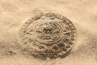 Aztec calendar stone carving on sand