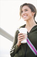 Hispanic woman outdoors with coffee