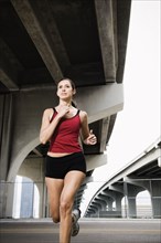 Hispanic woman running in urban area