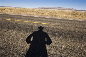 Shadow of cowboy on remote highway
