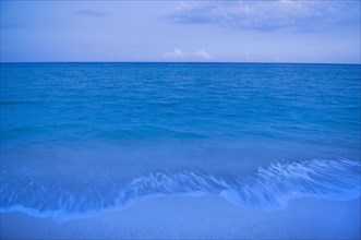 Waves on beach of tranquil blue ocean