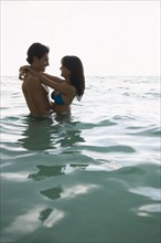 Smiling couple hugging in water