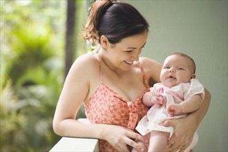 Mixed race mother smiling at baby