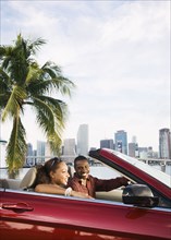 African American couple driving in convertible