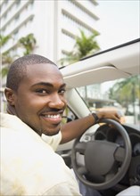 African American man driving convertible