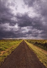 Rural road under cloudy sky