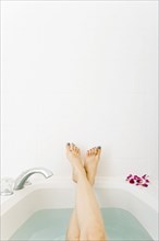Caucasian woman relaxing in bathtub