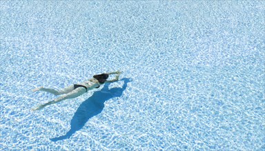 Mixed race woman swimming in clear water