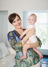 Caucasian mother holding baby in living room