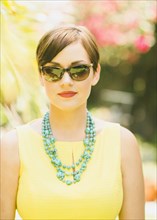 Caucasian woman wearing sunglasses and necklace outdoors