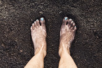 Mixed race woman barefoot in dirt