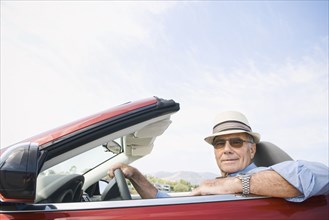 Older Caucasian man driving convertible