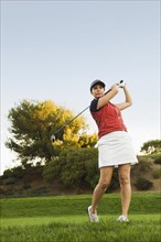 Caucasian woman playing golf on golf course