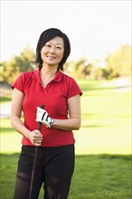 Korean woman playing golf on golf course