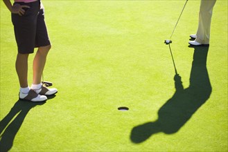 Women putting on green at golf course