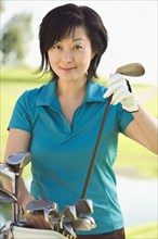 Korean woman choosing club on golf course