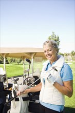 Caucasian woman selecting club on golf course