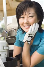 Korean woman smiling with golf clubs