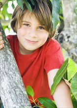 Caucasian boy smiling in tree