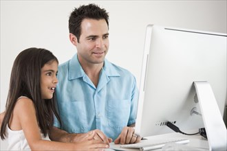 Mixed Race father and daughter using computer