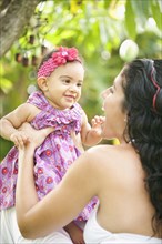 Mixed Race mother playing with baby daughter
