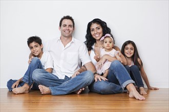 Portrait of smiling Mixed Race family sitting on floor